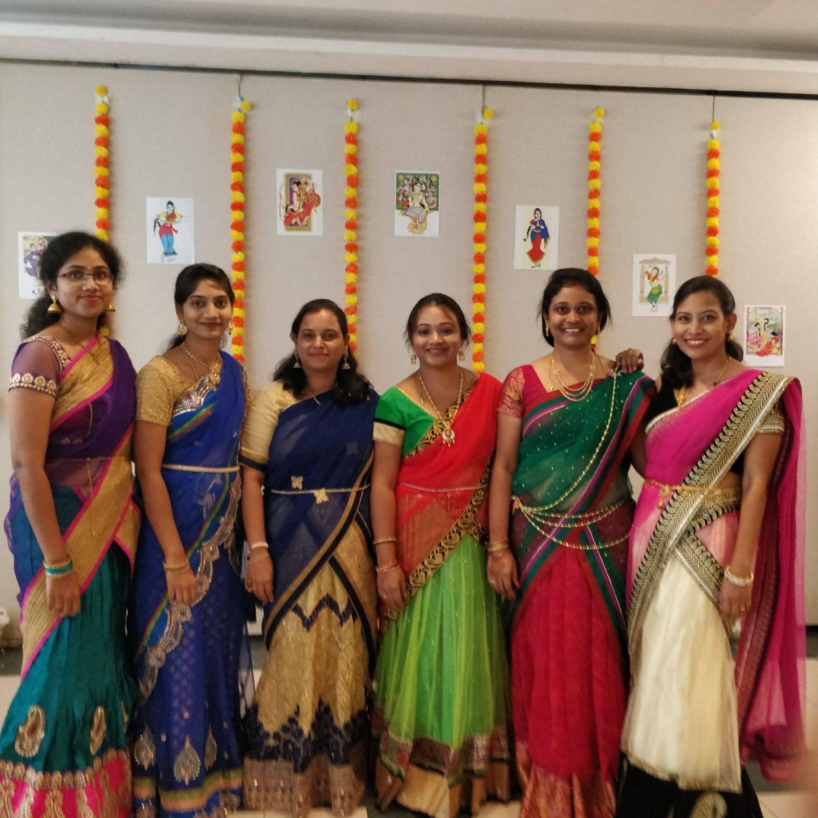 Ammulu members posing in colorful sarees at an event